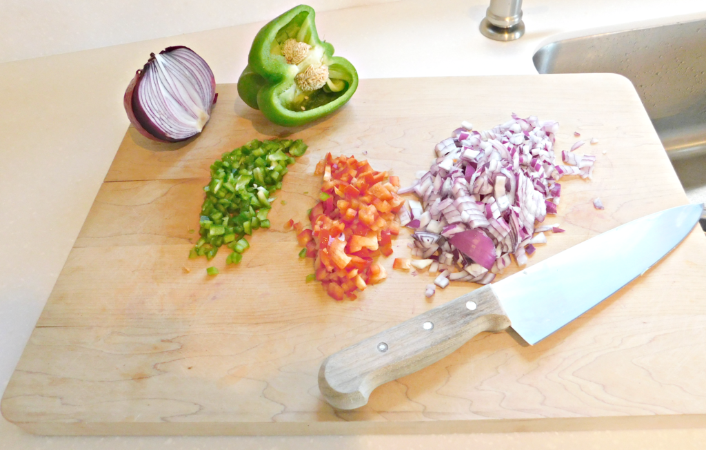 cutting board with diced peppers and red onion