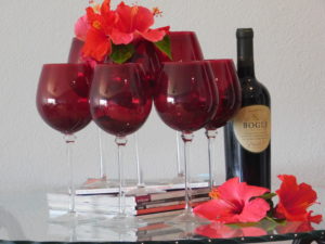 red wine glasses and hibiscus flowers with a bottle of red wine