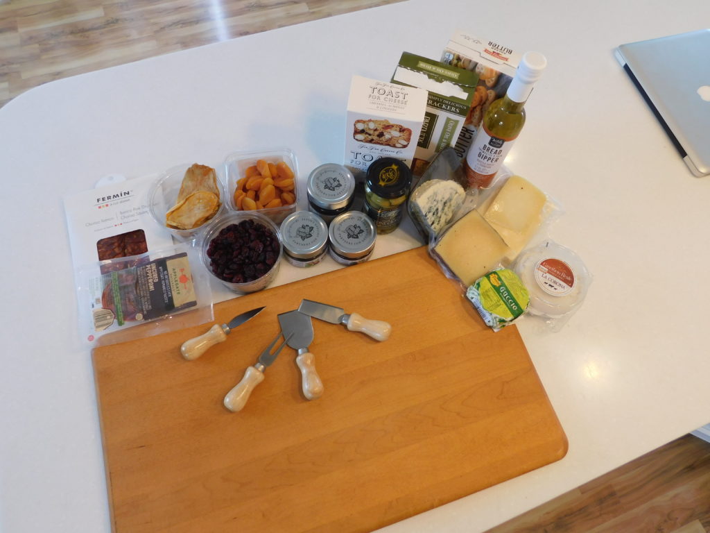 cheeseboard with jams, and assorted crackers and soft and hard cheeses with dried fruits and salty meats.