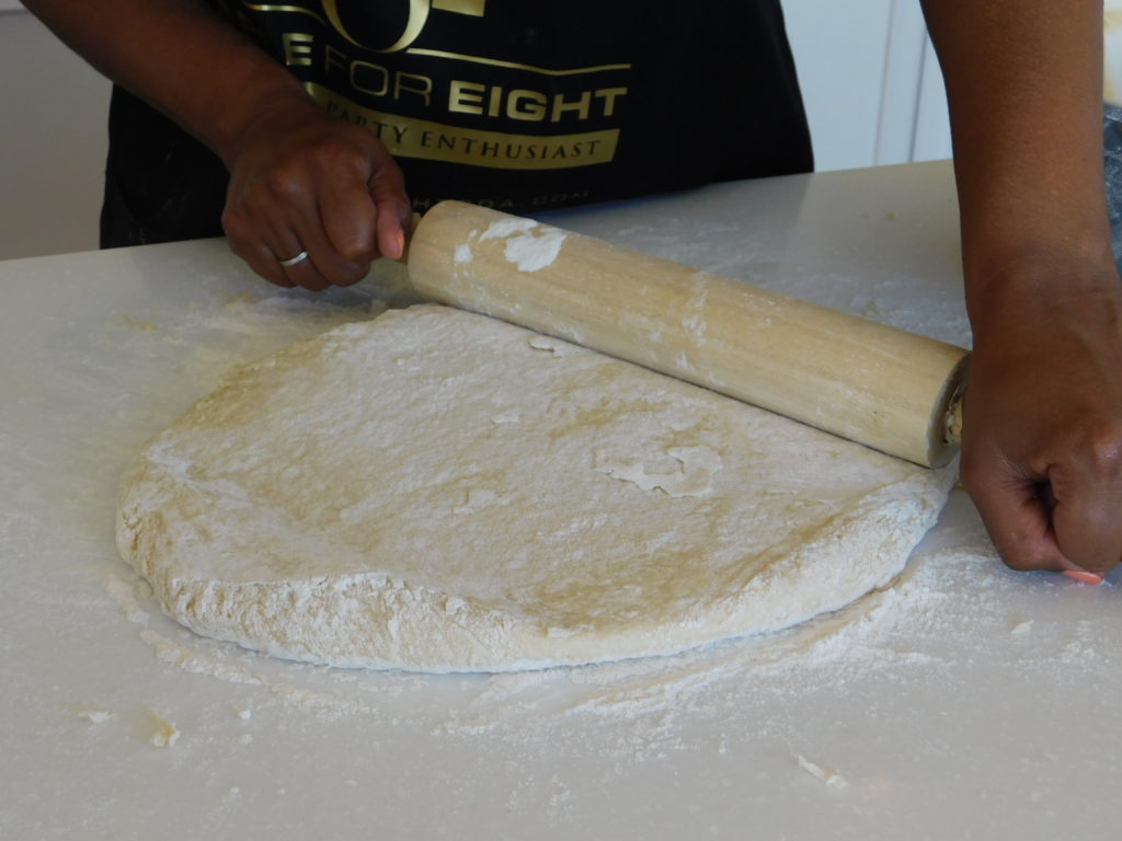 A rolling pin and dough being rolled out