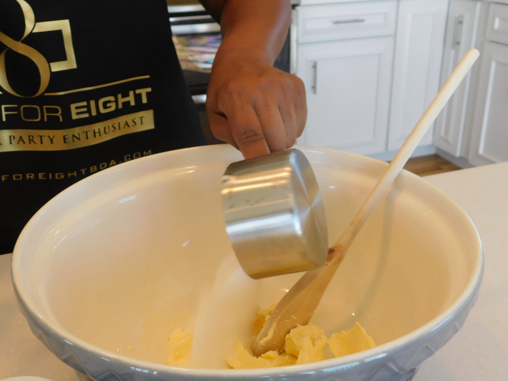 sugar being poured into a bowl with butter