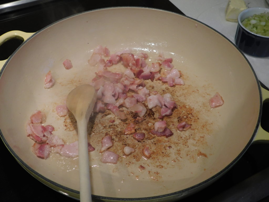 bacon in a skillet frying down.